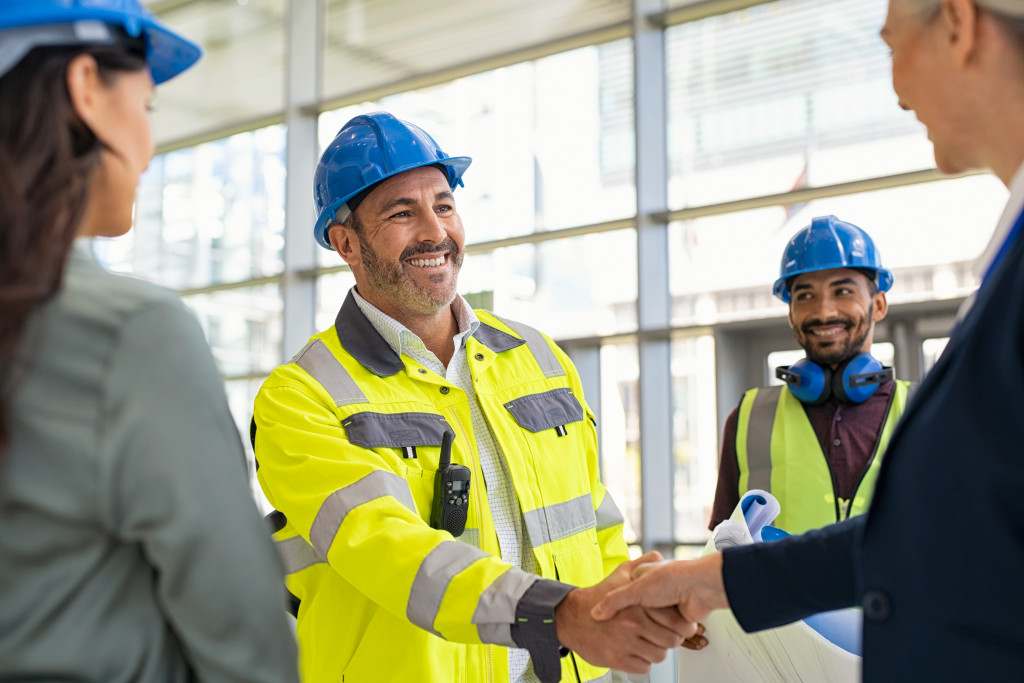 An engineer shaking hands with a manager in a construction site