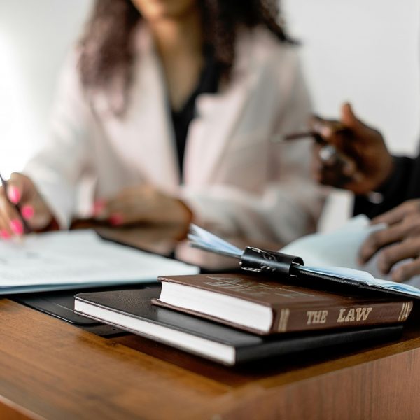 two professionals drafting contracts, with law books at the desk